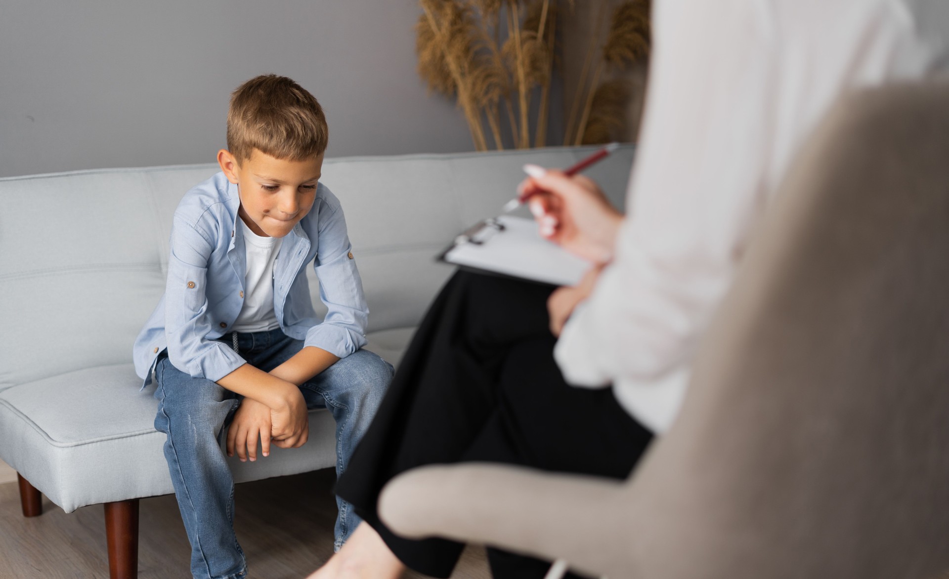 Psychologue professionnel pour enfants travaillant avec un écolier dans un bureau lumineux. Thérapie mentale pour enfants